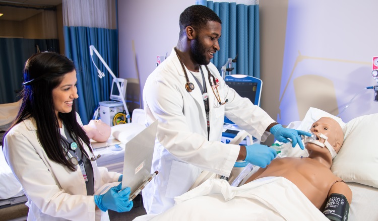 Students working with simulated patient in respiratory therapy lab